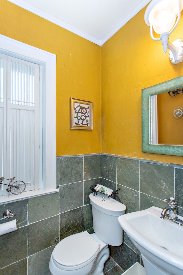 736 Chicago Blvd, Detroit, MI 48202 - bathroom with toilet, crown molding, tile walls, a sink, and a wainscoted wall