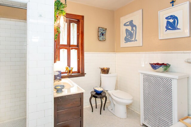736 Chicago Blvd, Detroit, MI 48202 - full bathroom featuring radiator, toilet, tile walls, tile patterned floors, and a wainscoted wall