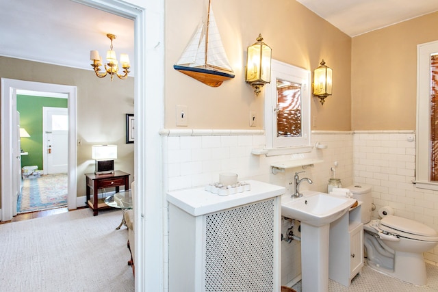 736 Chicago Blvd, Detroit, MI 48202 - bathroom featuring toilet, wainscoting, a chandelier, and tile walls