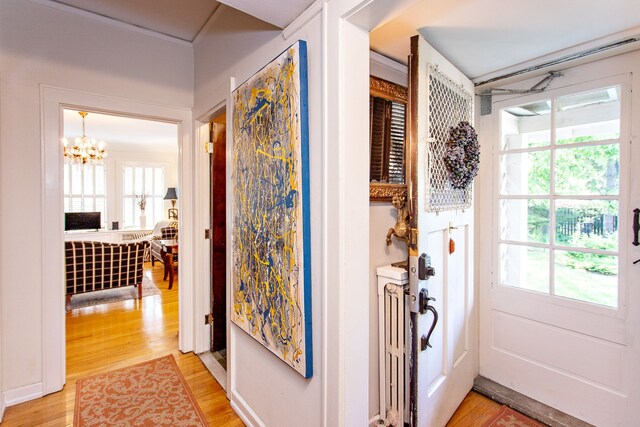 736 Chicago Blvd, Detroit, MI 48202 - hallway with light wood finished floors and a chandelier