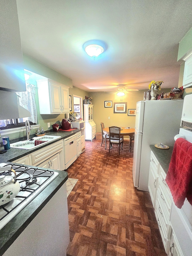 26541 Warner Ave, Warren, MI 48091 - kitchen with a sink, dark countertops, white dishwasher, range with gas cooktop, and white cabinetry