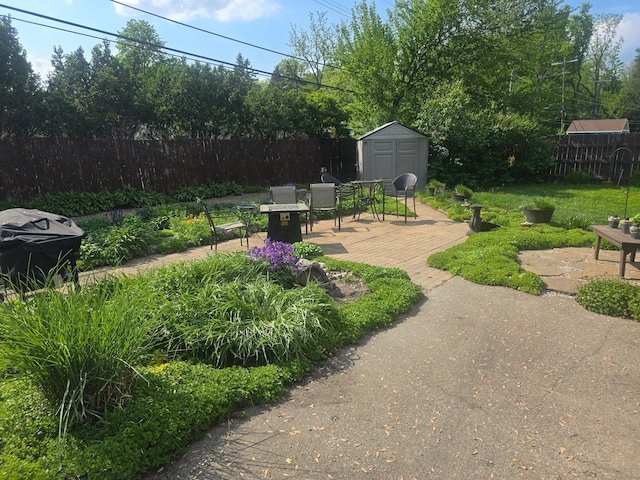 26541 Warner Ave, Warren, MI 48091 - fenced backyard featuring a storage unit, outdoor dining area, an outdoor structure, and a patio area
