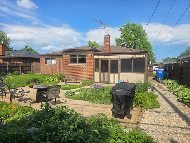 26541 Warner Ave, Warren, MI 48091 - rear view of house with fence, an outdoor fire pit, brick siding, a chimney, and a patio area
