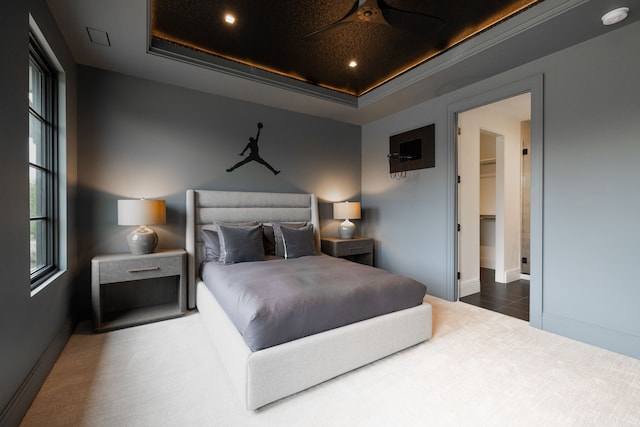 bedroom featuring a tray ceiling and baseboards