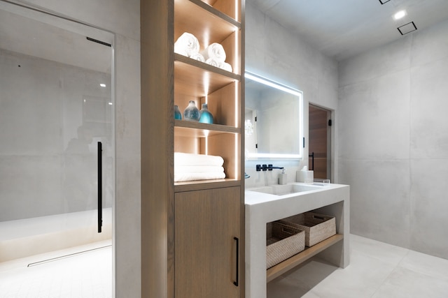 full bath with walk in shower, vanity, and tile patterned flooring