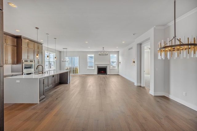5636 Suffolk Ct, West Bloomfield, MI 48322 - kitchen featuring wood finished floors, light countertops, open floor plan, a chandelier, and baseboards