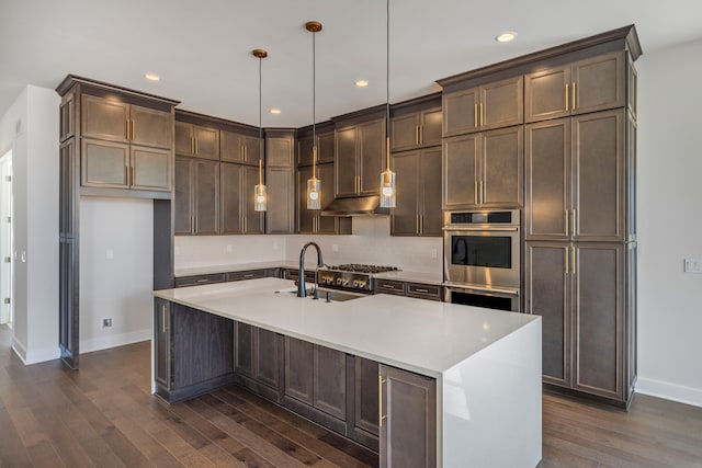 5636 Suffolk Ct, West Bloomfield, MI 48322 - kitchen featuring baseboards, appliances with stainless steel finishes, dark wood finished floors, light countertops, and a kitchen island with sink