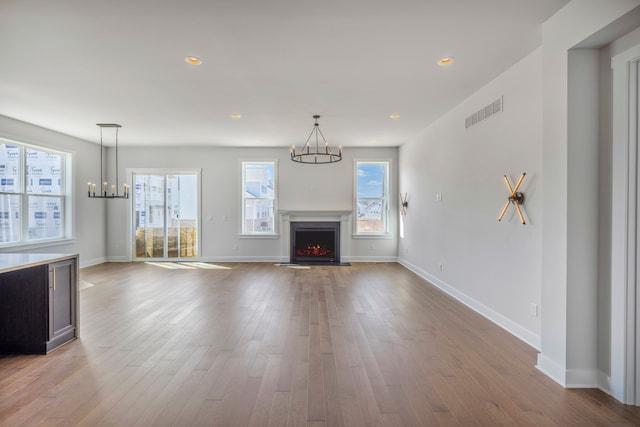5636 Suffolk Ct, West Bloomfield, MI 48322 - unfurnished living room with a chandelier, wood finished floors, baseboards, a warm lit fireplace, and recessed lighting