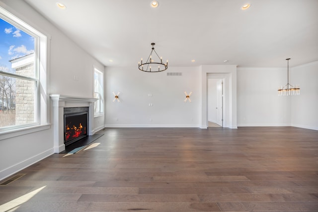 5636 Suffolk Ct, West Bloomfield, MI 48322 - unfurnished living room with a chandelier, a warm lit fireplace, wood finished floors, recessed lighting, and baseboards