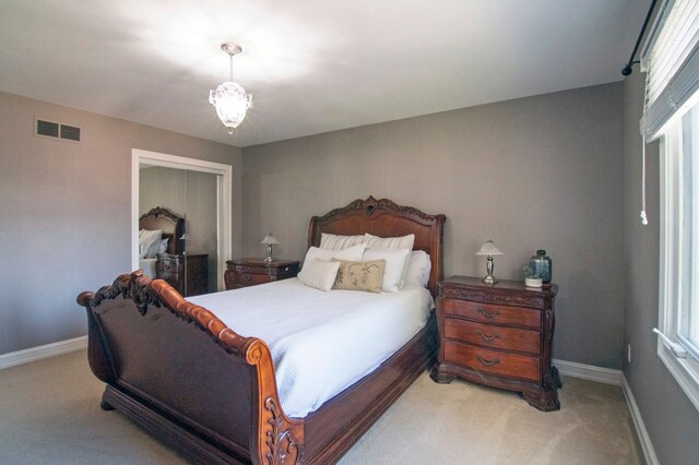 194 W Reed Lk, Commerce Twp, MI 48390 - bedroom with light carpet, baseboards, a closet, and a chandelier