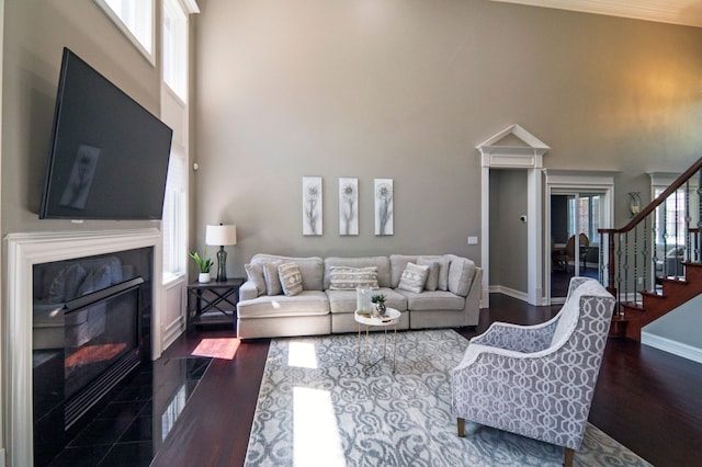 194 W Reed Lk, Commerce Twp, MI 48390 - living area with a fireplace with flush hearth, a towering ceiling, stairs, baseboards, and dark wood finished floors