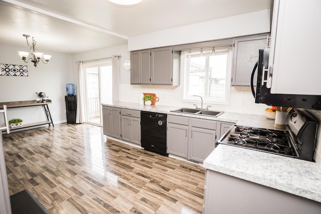 11748 Cloverview Dr, Ravenna, MI 49451 - kitchen featuring black dishwasher, a sink, gas stove, gray cabinetry, and tasteful backsplash
