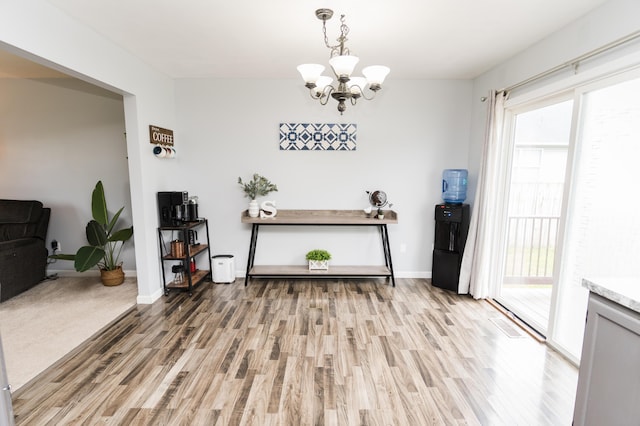 11748 Cloverview Dr, Ravenna, MI 49451 - dining room featuring light wood-style flooring, a chandelier, plenty of natural light, and baseboards
