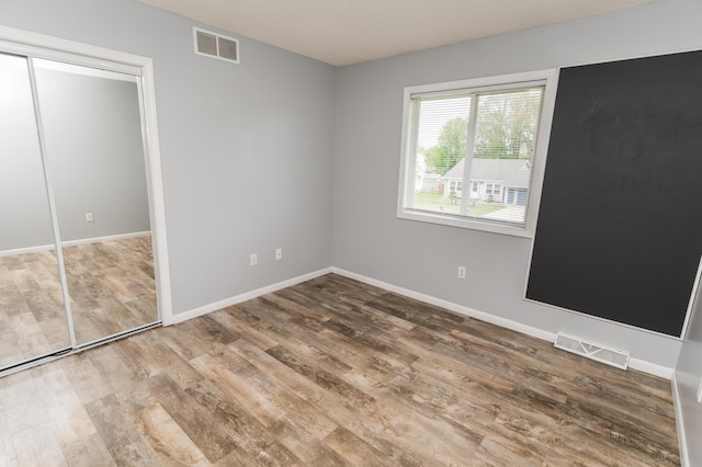 11748 Cloverview Dr, Ravenna, MI 49451 - unfurnished bedroom featuring wood finished floors, baseboards, and a closet