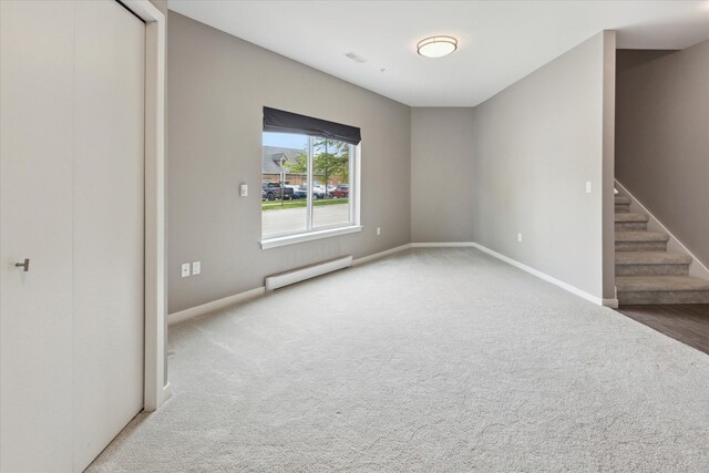 293 N 2nd St, Brighton, MI 48116 - empty room with a baseboard heating unit, carpet, stairs, and baseboards
