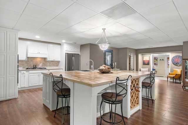 08763 Silver Lake Rd, Grand Junction, MI 49056 - kitchen with appliances with stainless steel finishes, butcher block countertops, dark wood-style flooring, premium range hood, and a drop ceiling