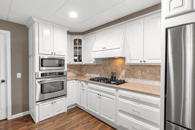 08763 Silver Lake Rd, Grand Junction, MI 49056 - kitchen featuring appliances with stainless steel finishes, dark wood-style floors, glass insert cabinets, decorative backsplash, and white cabinets