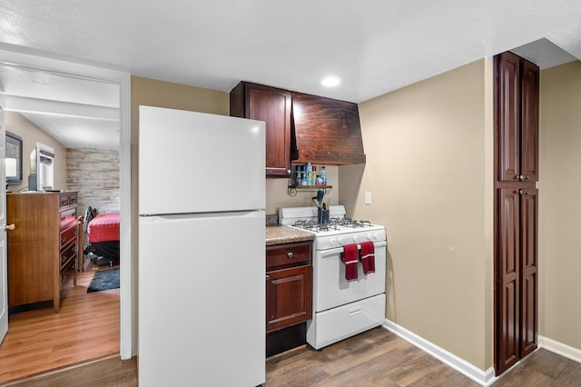 08763 Silver Lake Rd, Grand Junction, MI 49056 - kitchen with white appliances, custom range hood, wood finished floors, light countertops, and recessed lighting
