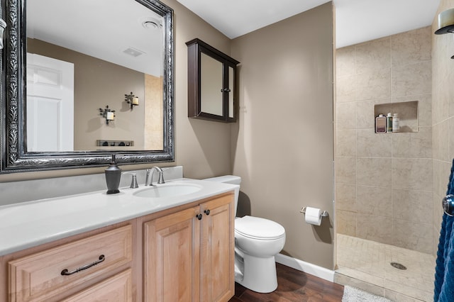 08763 Silver Lake Rd, Grand Junction, MI 49056 - bathroom featuring wood finished floors, a tile shower, toilet, vanity, and baseboards