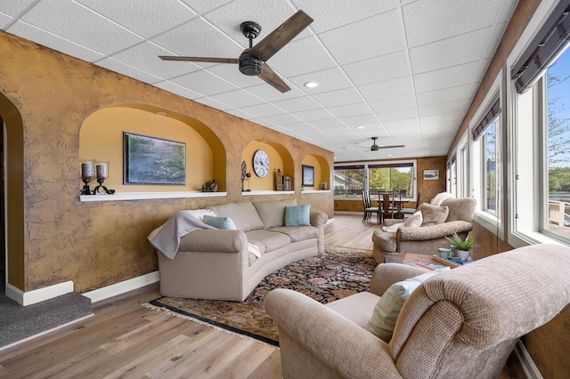 08763 Silver Lake Rd, Grand Junction, MI 49056 - living area with ceiling fan, wood finished floors, baseboards, a paneled ceiling, and arched walkways