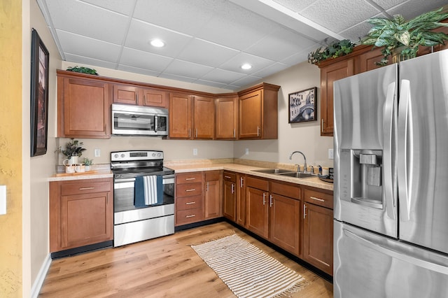 08763 Silver Lake Rd, Grand Junction, MI 49056 - kitchen with stainless steel appliances, a sink, light countertops, a drop ceiling, and light wood finished floors