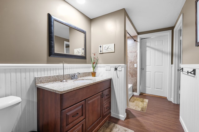 08763 Silver Lake Rd, Grand Junction, MI 49056 - bathroom featuring a wainscoted wall, wood finished floors, vanity, toilet, and shower / tub combination