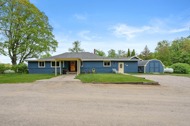 08763 Silver Lake Rd, Grand Junction, MI 49056 - ranch-style home featuring gravel driveway, a storage shed, an outbuilding, a front lawn, and a chimney