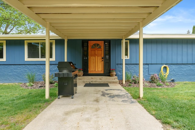 08763 Silver Lake Rd, Grand Junction, MI 49056 - doorway to property with board and batten siding, a lawn, and a carport