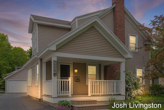 957 Breton Rd SE, Grand Rapids, MI 49506 - view of front facade with covered porch, a chimney, an outbuilding, and a garage