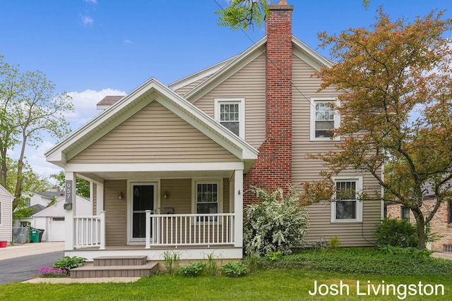 957 Breton Rd SE, Grand Rapids, MI 49506 - view of front facade with a porch, a chimney, a garage, and a front yard
