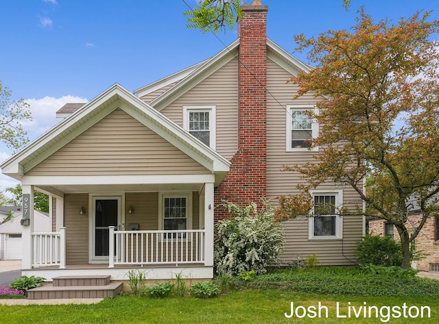 957 Breton Rd SE, Grand Rapids, MI 49506 - view of front of house featuring a porch, a chimney, a front lawn, and a garage