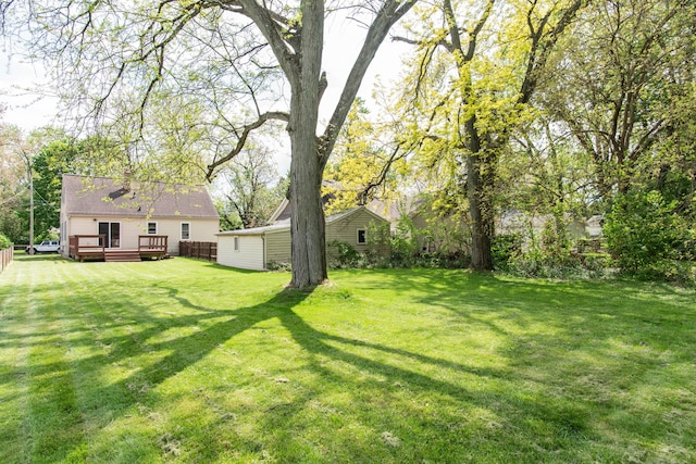 view of grassy yard with a wooden deck