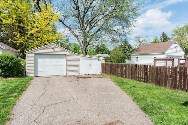 detached garage with fence and driveway