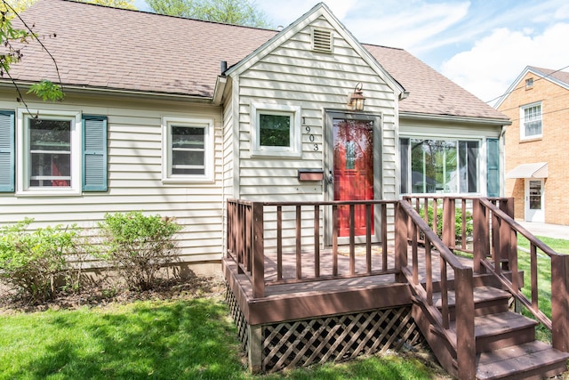 view of front of property with roof with shingles and a front lawn