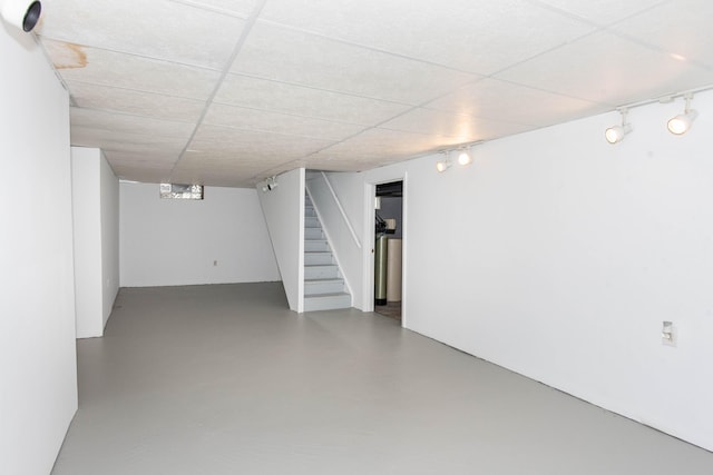 finished basement with stairway and track lighting