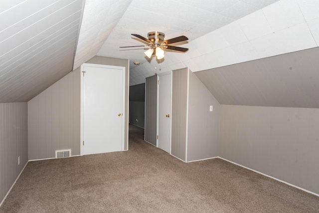 additional living space featuring carpet, lofted ceiling, and ceiling fan