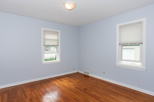 spare room featuring dark wood finished floors and baseboards