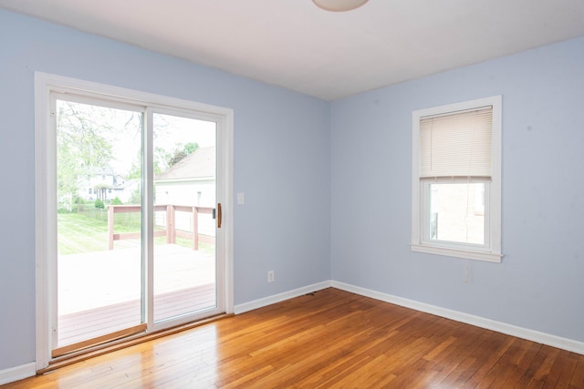 unfurnished room with plenty of natural light, light wood finished floors, and baseboards