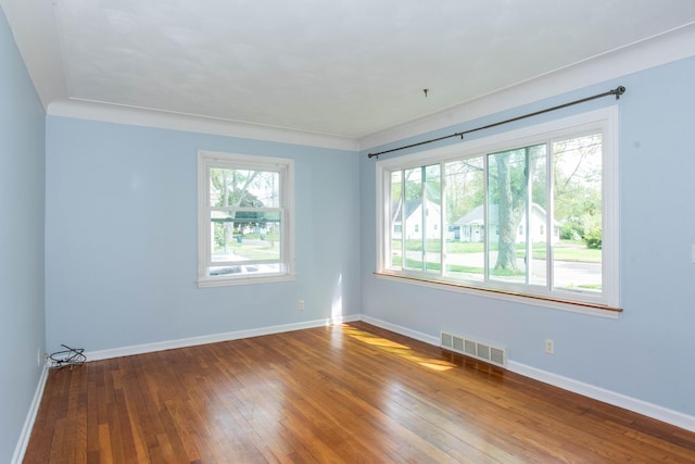 empty room featuring wood-type flooring and baseboards