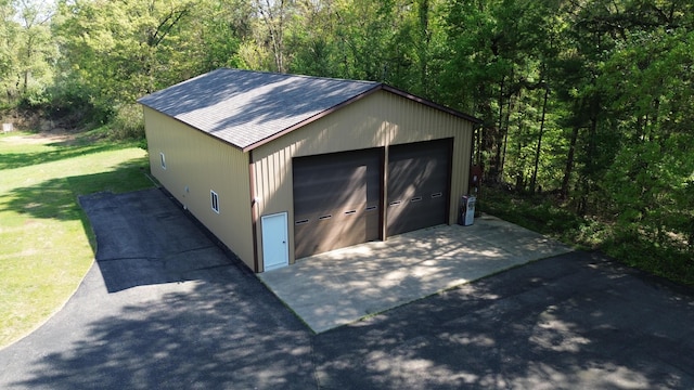 detached garage featuring a view of trees