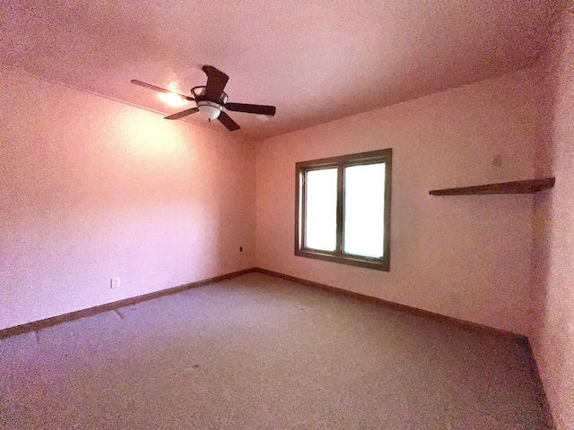 carpeted spare room with baseboards, a ceiling fan, and a textured ceiling
