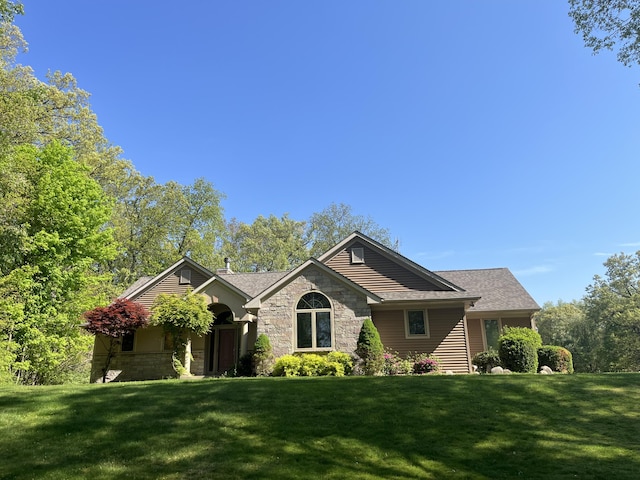 ranch-style house with a front lawn and stone siding