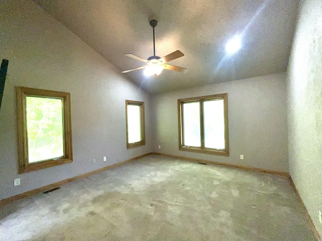 carpeted empty room featuring vaulted ceiling, ceiling fan, and baseboards