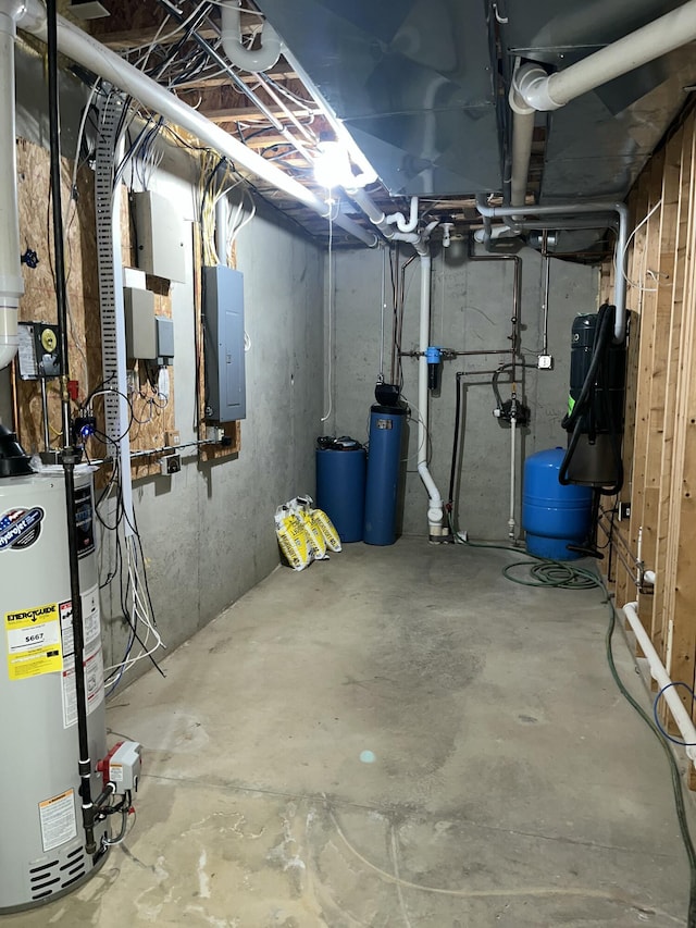 unfinished below grade area featuring gas water heater, a water pressure tank, and electric panel
