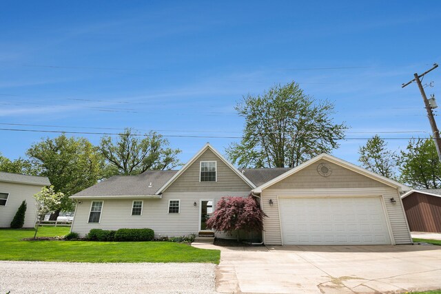 view of front of house with a front yard, an attached garage, and concrete driveway