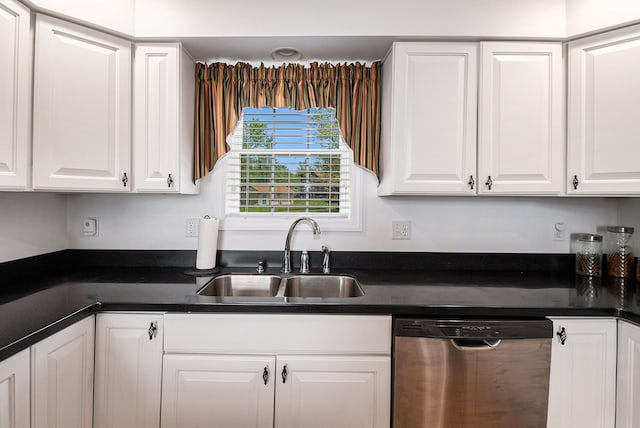 kitchen featuring stainless steel dishwasher, a sink, white cabinets, and dark countertops