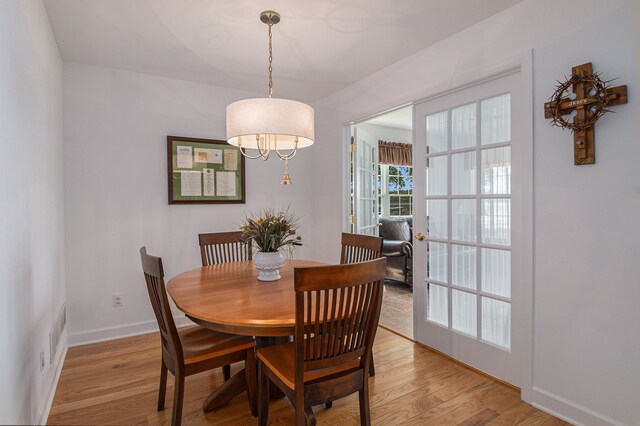 dining room featuring light wood-type flooring and baseboards