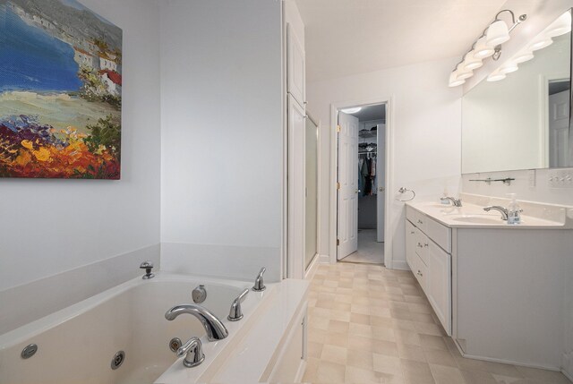 bathroom featuring a whirlpool tub, vanity, a walk in closet, tile patterned floors, and a stall shower
