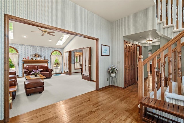 46890 Cider Mill Dr, Novi, MI 48374 - foyer with wallpapered walls, stairway, wood finished floors, a ceiling fan, and a skylight
