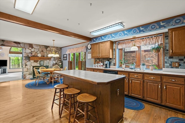 46890 Cider Mill Dr, Novi, MI 48374 - kitchen with a sink, tile counters, light wood-style floors, dishwasher, and a breakfast bar